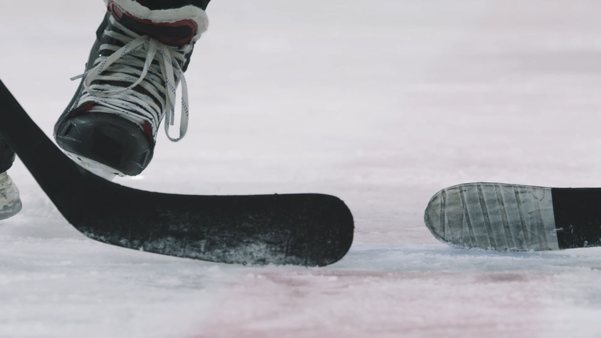 Video von Eishockey Schlägern, Schlittschuhen und Puck beim Bully.