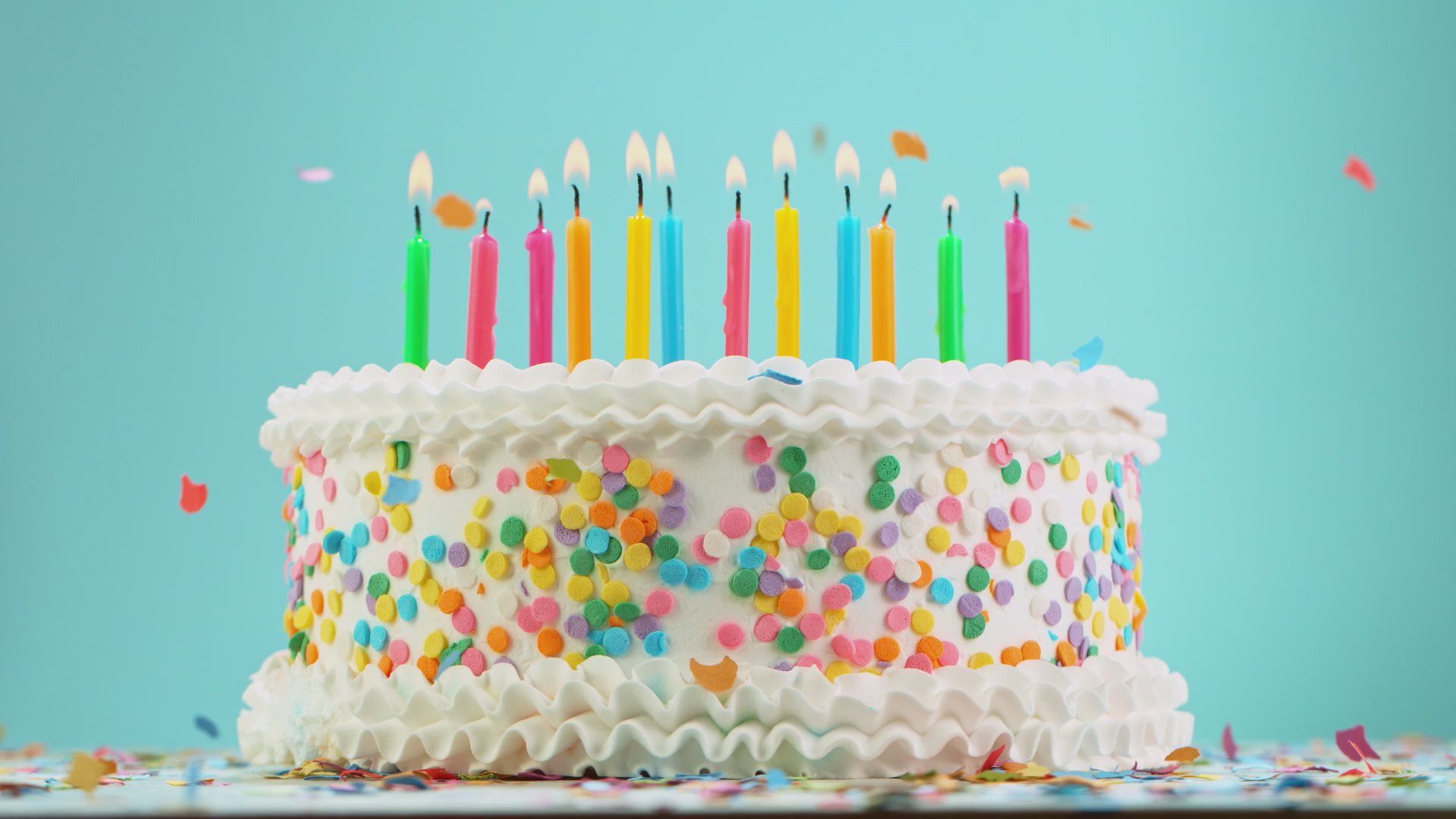 Video of a Birthday cake with burning candles and flying confetti