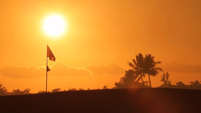 Video eines Golfplatzes mit wehender Fahne im Sonnenuntergang