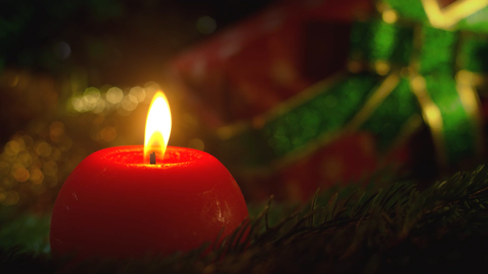 Video von brenndender roter Kerze mit Weihnachtsgeschenk