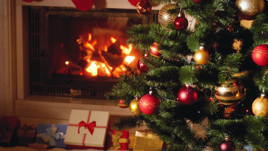 Video of a fire place with burning wood and Christmas Tree with blinking lights